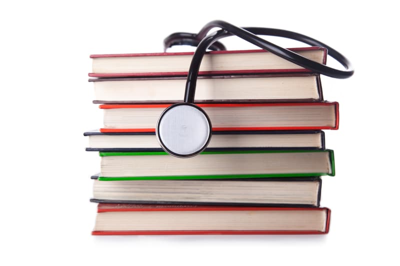 stapel boeken, met docters apparaat er op