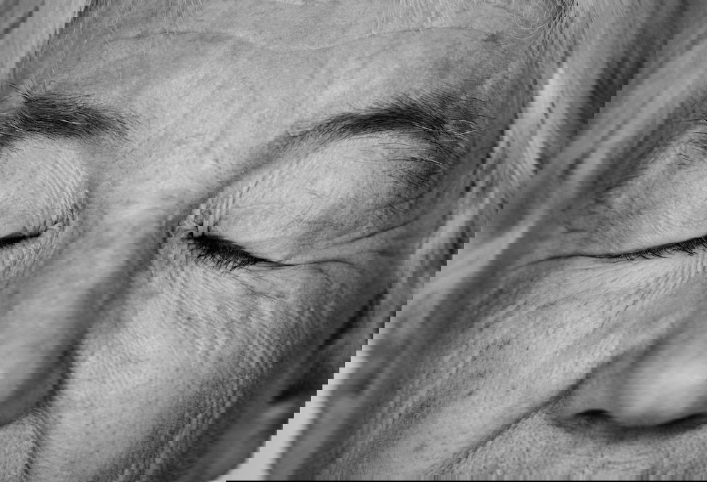Black and white portrait of a white elderly woman eyes closed