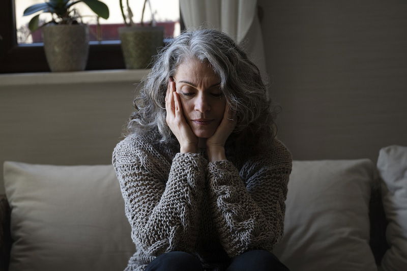 sad elder woman sofa