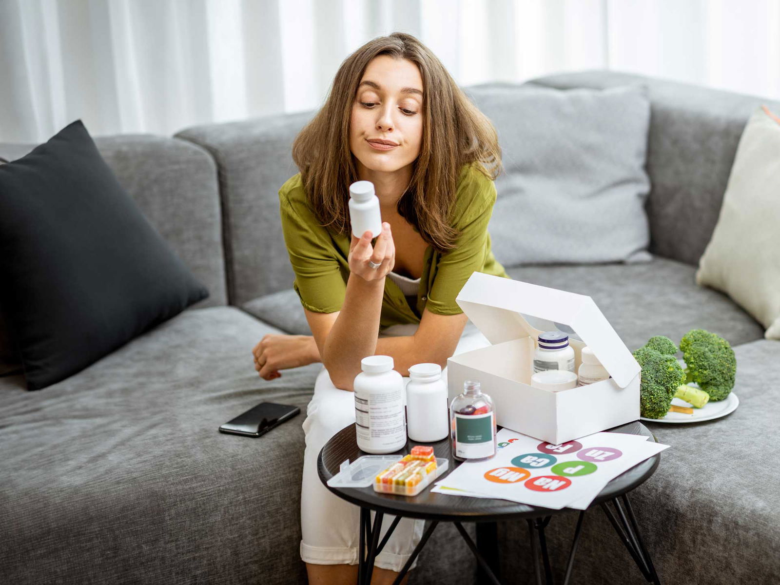 vrouw die naar een vitamine kijk, Kun je te veel vitaminen binnenkrijgen